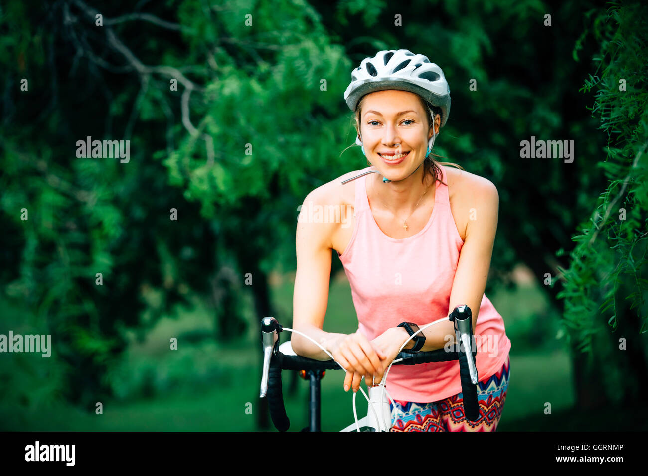 Smiling Caucasian woman leaning on Vélo guidon Banque D'Images