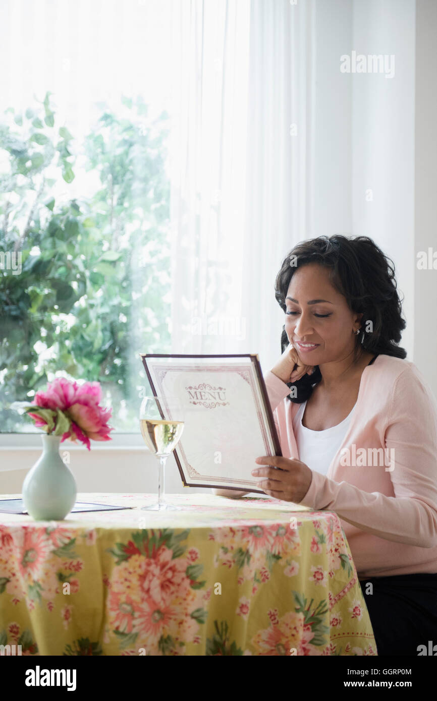 Black woman reading menu in restaurant Banque D'Images