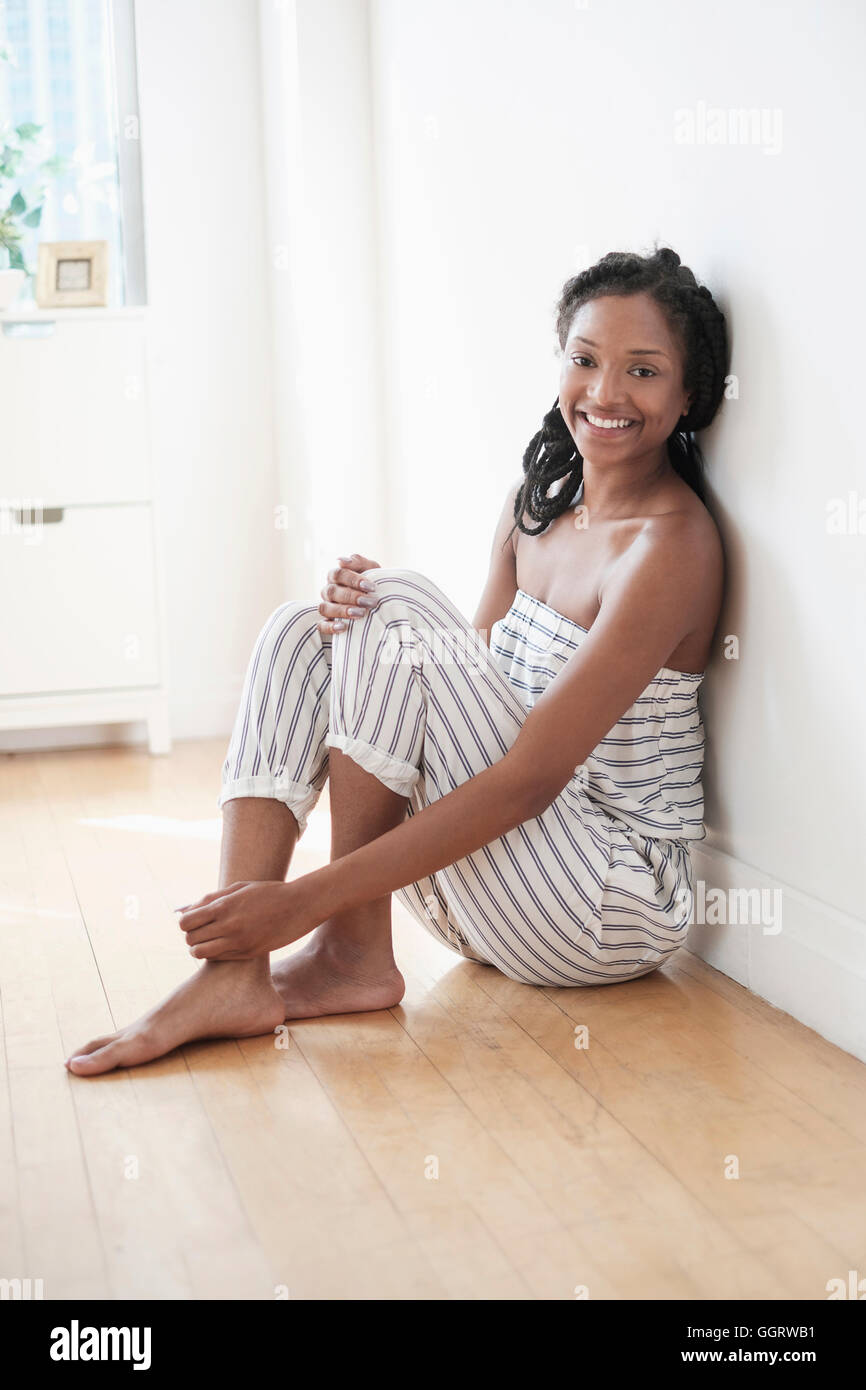 Smiling black woman sitting on floor Banque D'Images