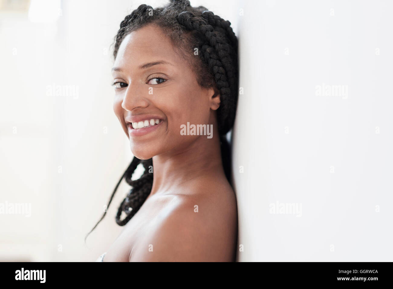 Smiling black woman leaning on wall Banque D'Images