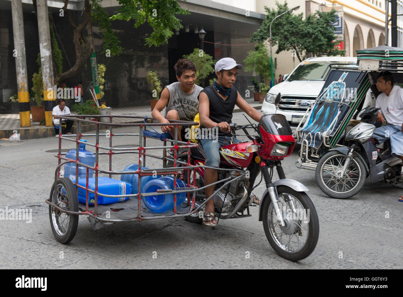 Les garçons sur la prestation de vélo de l'eau potable dans la région métropolitaine de Manille, Philippines Banque D'Images