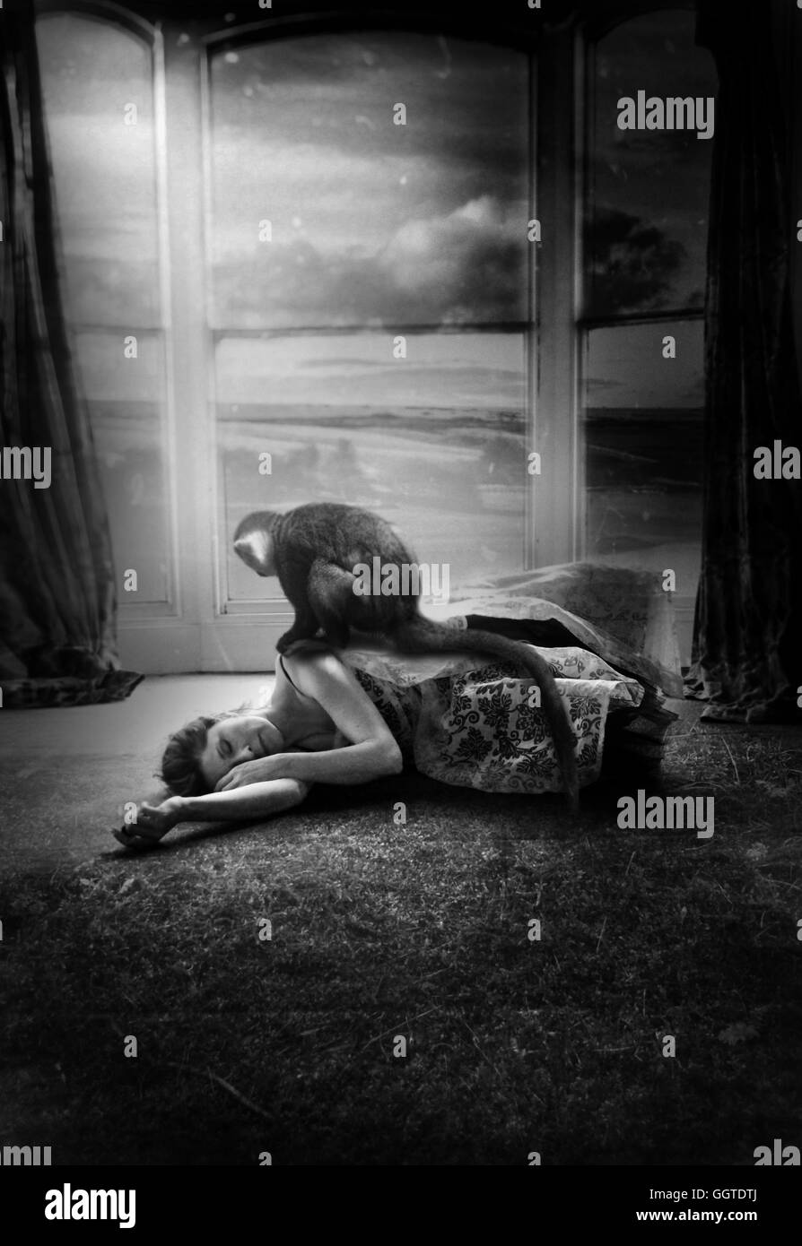 Photo surréaliste de la femme couchée sur le tapis avec le Singe assis sur son bras Banque D'Images