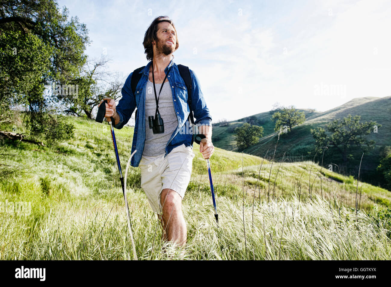 Caucasian man randonnées en montagne sur l'herbe Banque D'Images