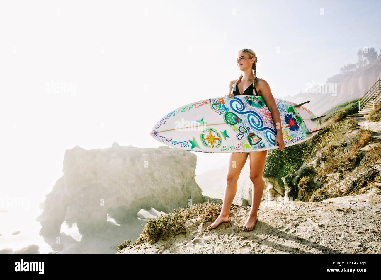 Portrait woman carrying surfboard at beach Banque D'Images