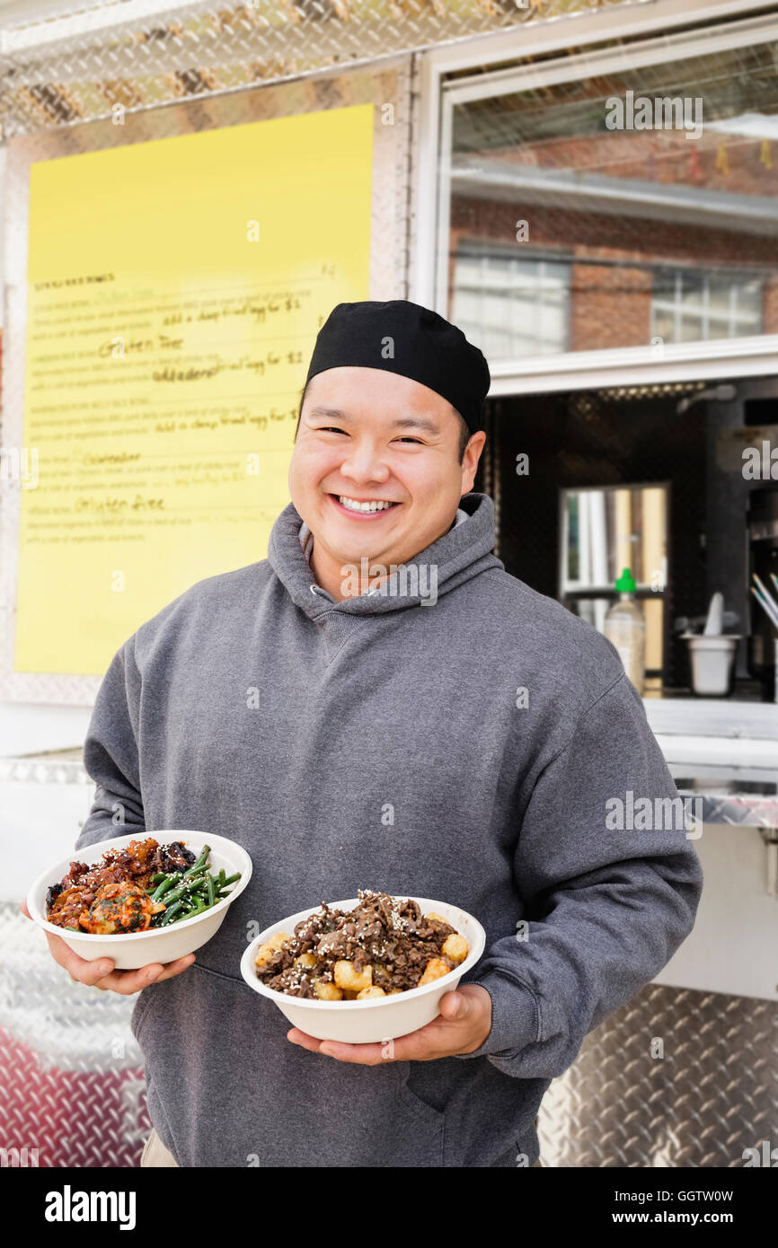 Asian man holding bols de nourriture à camion alimentaire Banque D'Images