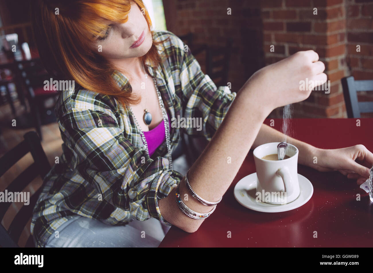 Caucasian woman dans le café de sucre d'arrosage Banque D'Images