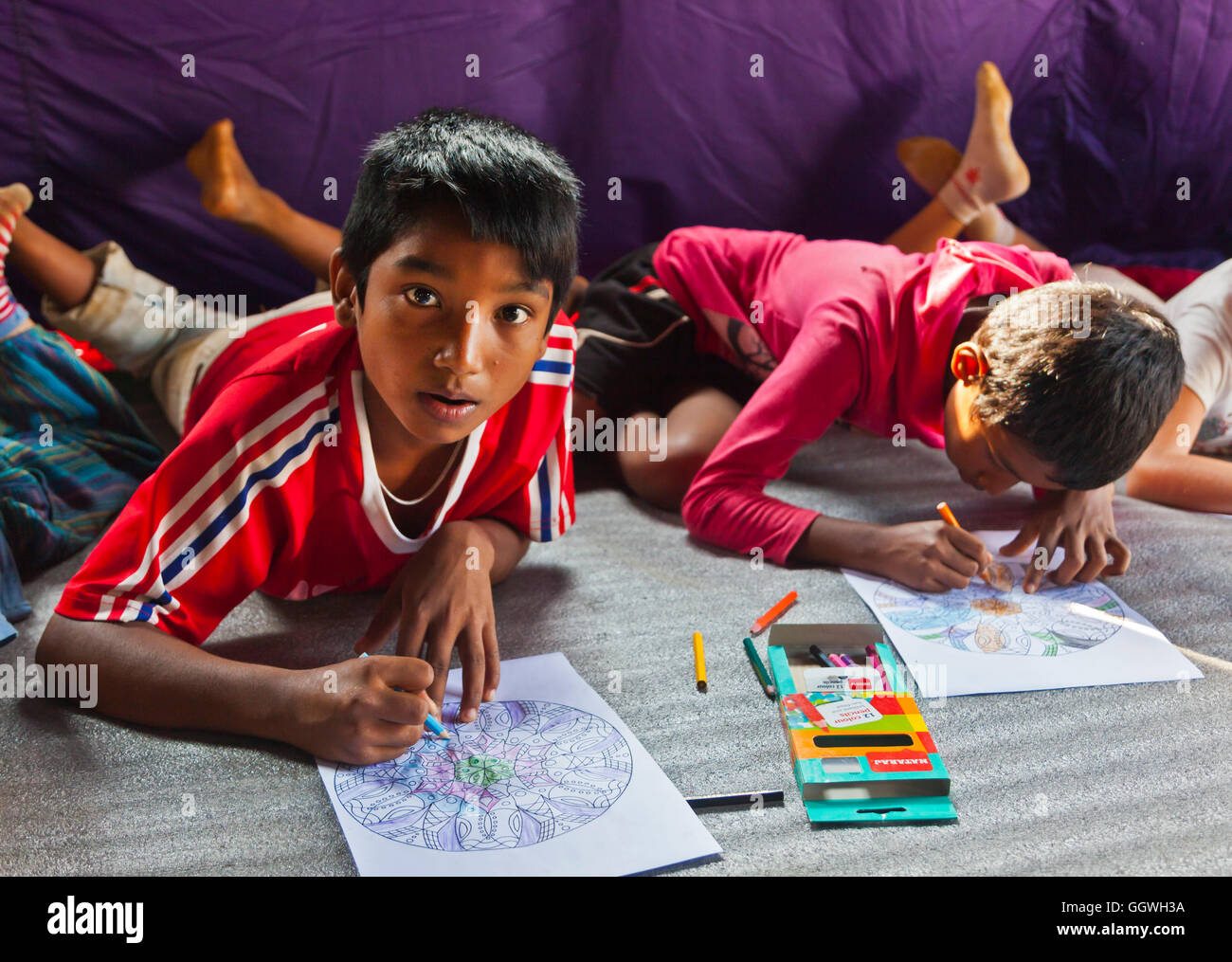 Enfants de dessiner dans le cadre d'un programme d'phychotherapy dans un village a été mis sur pied par la Société de développement et le Népal HDSN Banque D'Images