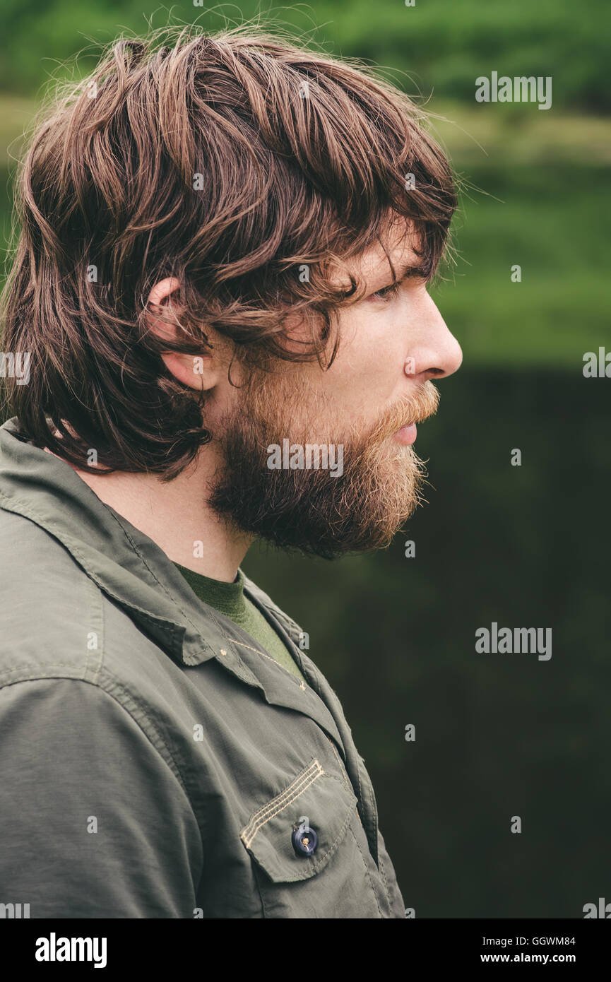 Jeune homme cheveux bouclés barbu portrait de vie de plein air travel  concept nature sur Vue de côté l'arrière-plan Photo Stock - Alamy