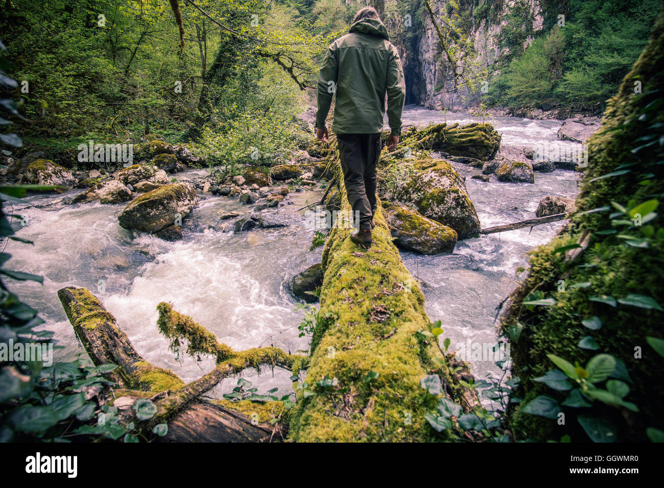 Man Traveler crossing river sur la survie du journal de voyage de vie de plein air concept Banque D'Images