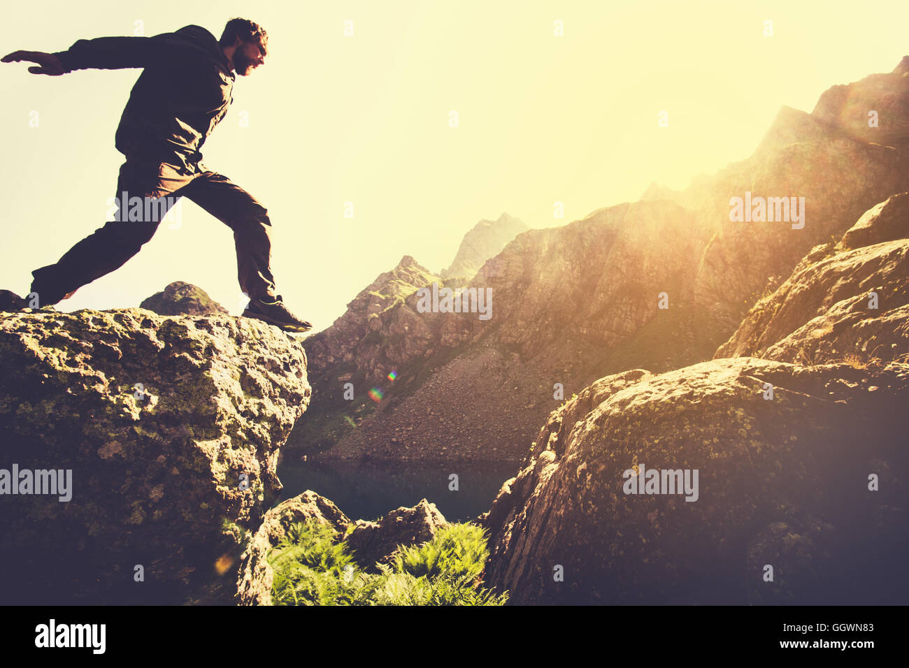 Homme qui court sur les montagnes falaise saut sur le lac de Skyrunning sport Lifestyle Travel concept outdoor Banque D'Images