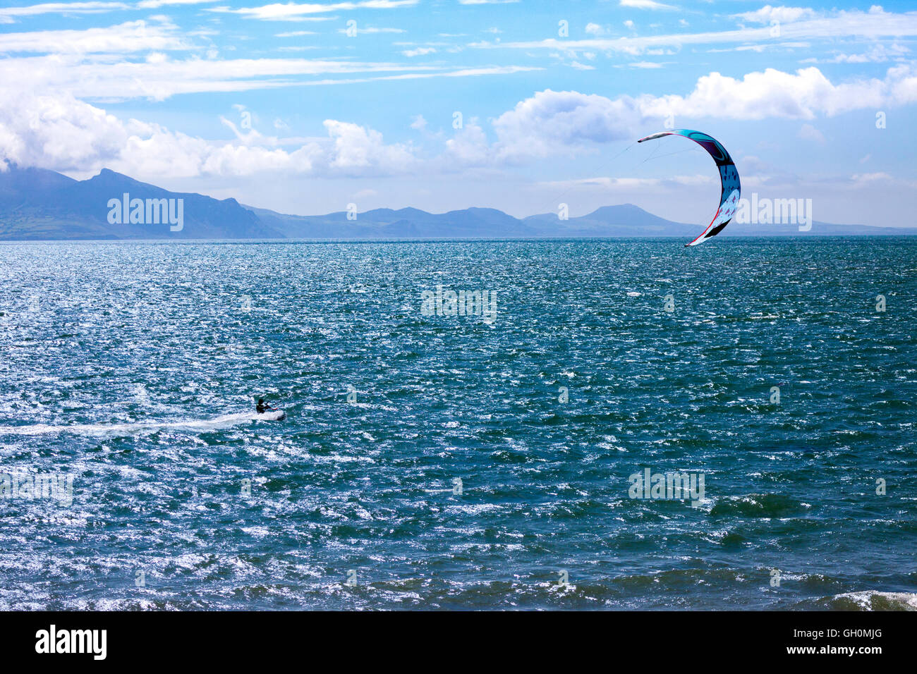 Kite boarder appréciant le Vent et météo sur la plage de Newborough, Anglesey, Pays de Galles, Royaume-Uni Banque D'Images