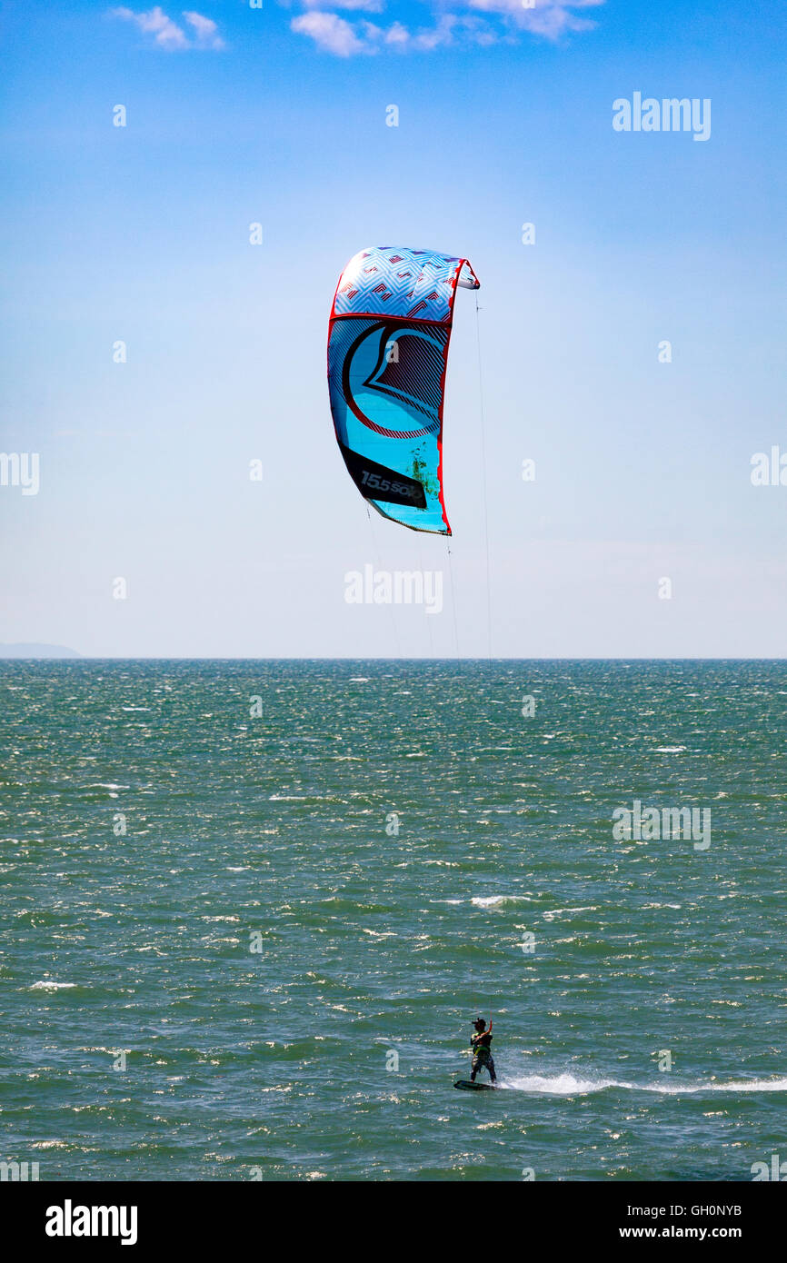 Kite boarder appréciant le Vent et météo sur la plage de Newborough, Anglesey, Pays de Galles, Royaume-Uni Banque D'Images