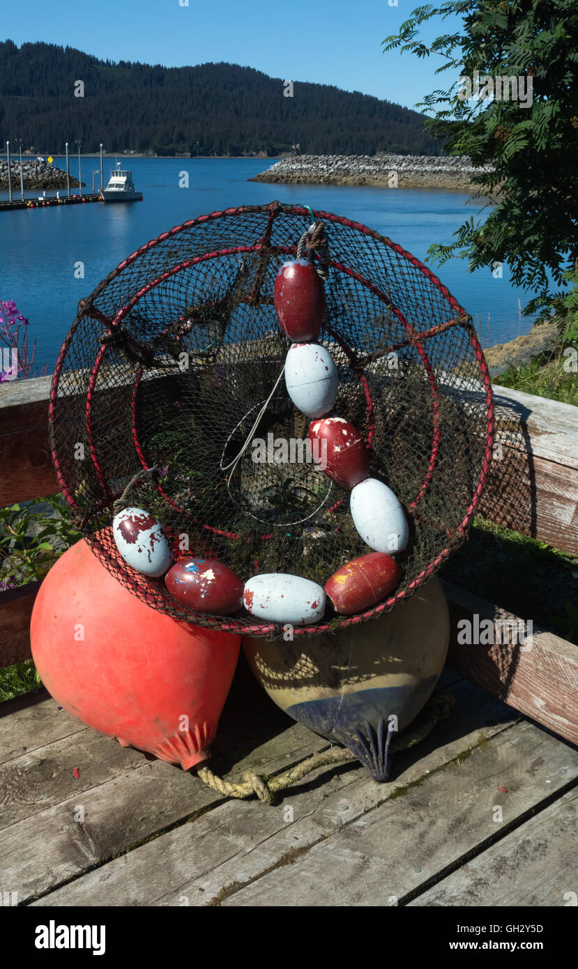 Un crabpot associées et des bouées sont empilés contre une rampe en bois. Banque D'Images