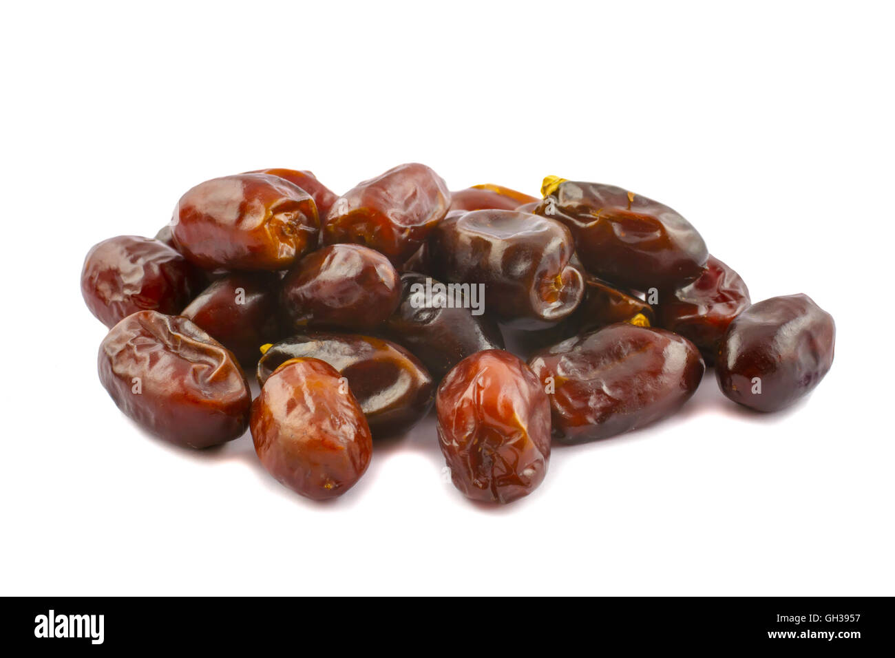 Un tas de dates brun doré isolé sur un fond blanc. Banque D'Images