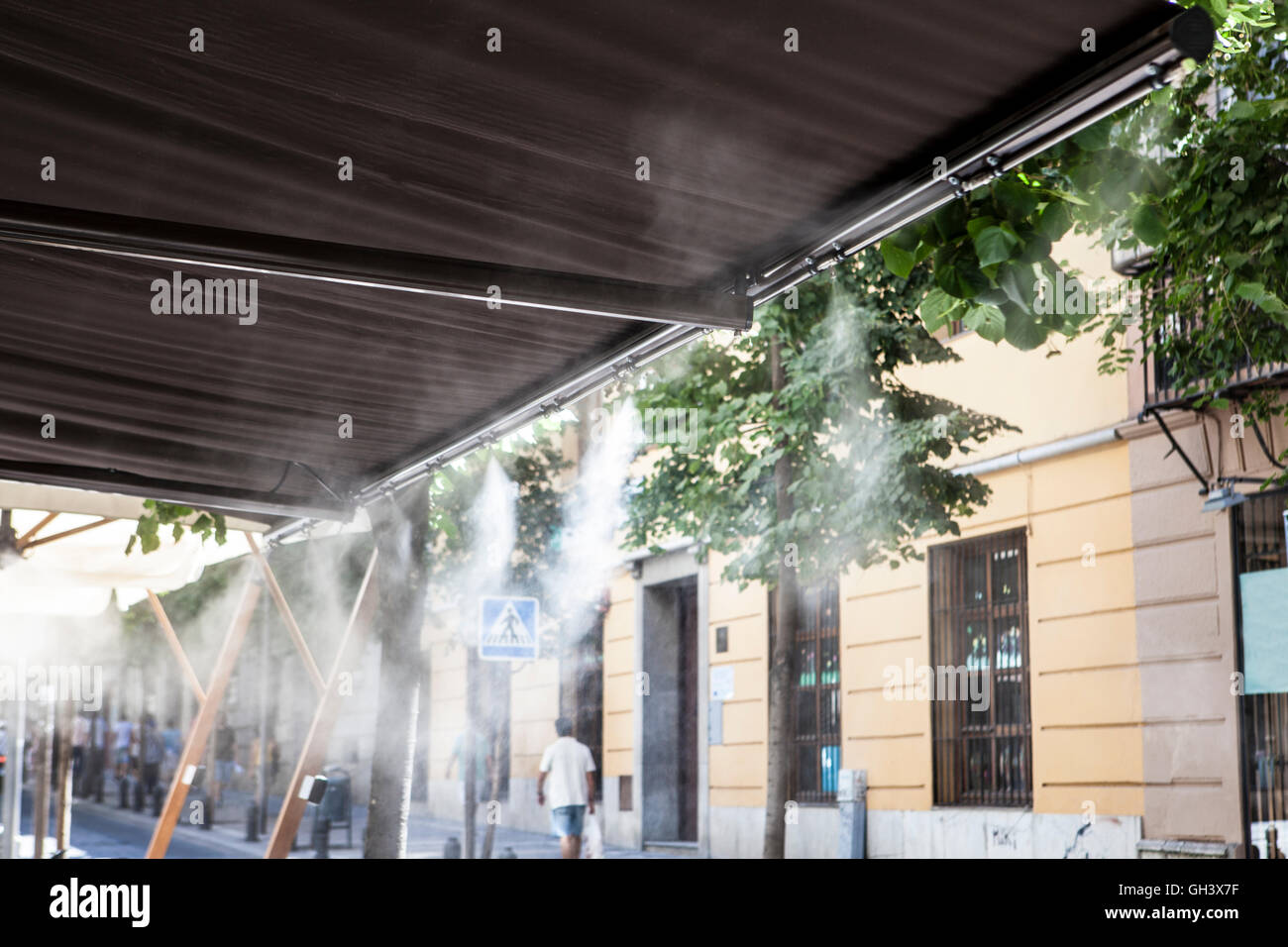 L'eau vaporisée éclaboussures sprinkleurs auvent terrasse au bar afin de refroidir la température de l'été en Espagne Banque D'Images