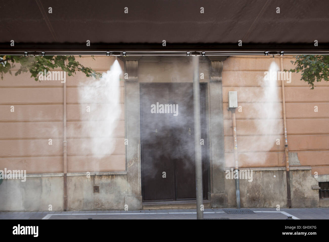 L'eau vaporisée éclaboussures sprinkleurs auvent terrasse au bar afin de refroidir la température de l'été en Espagne Banque D'Images