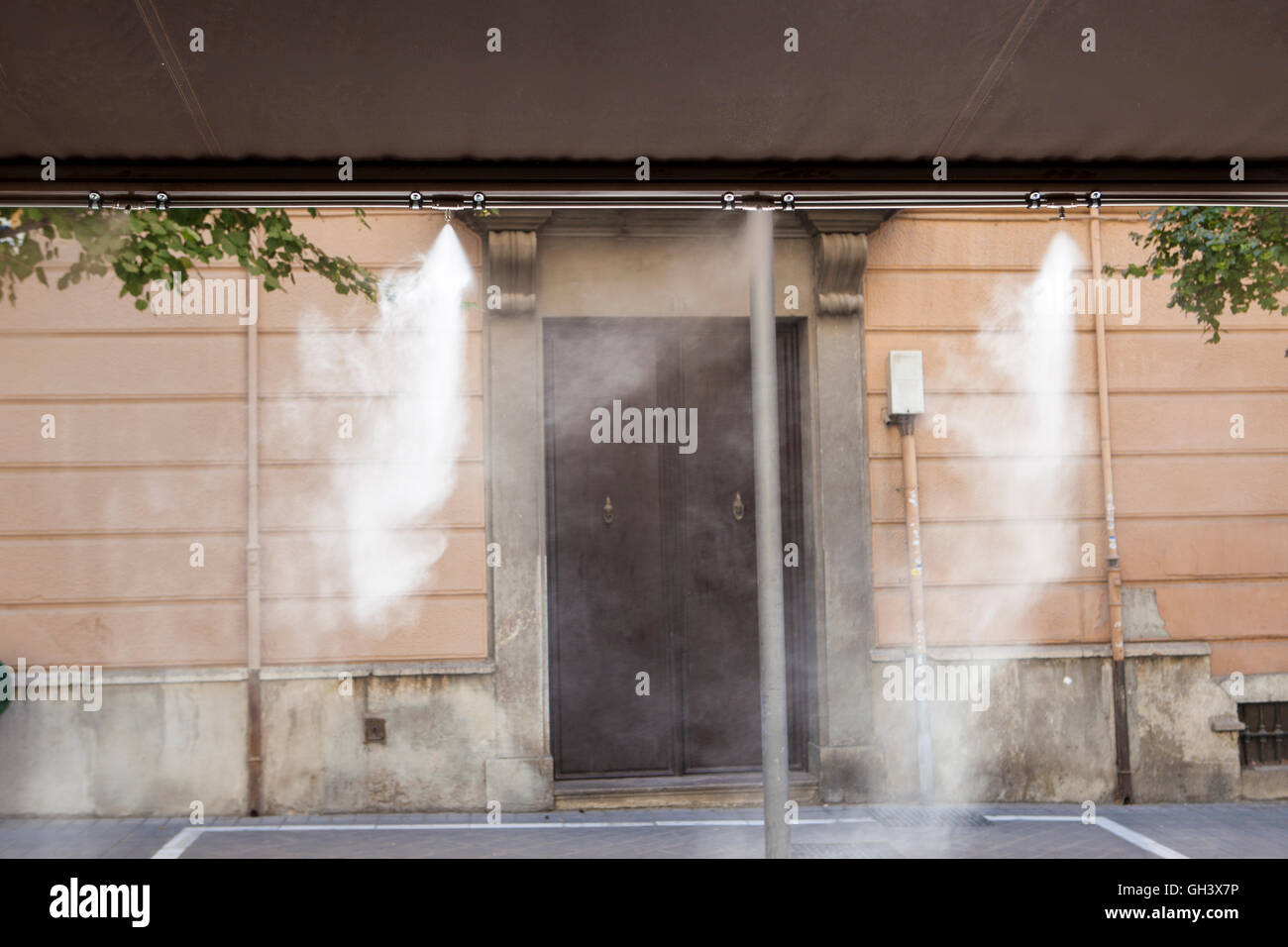 L'eau vaporisée éclaboussures sprinkleurs auvent terrasse au bar afin de refroidir la température de l'été en Espagne Banque D'Images