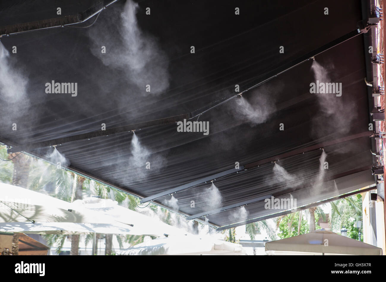 L'eau vaporisée éclaboussures sprinkleurs auvent terrasse au bar afin de refroidir la température de l'été en Espagne Banque D'Images
