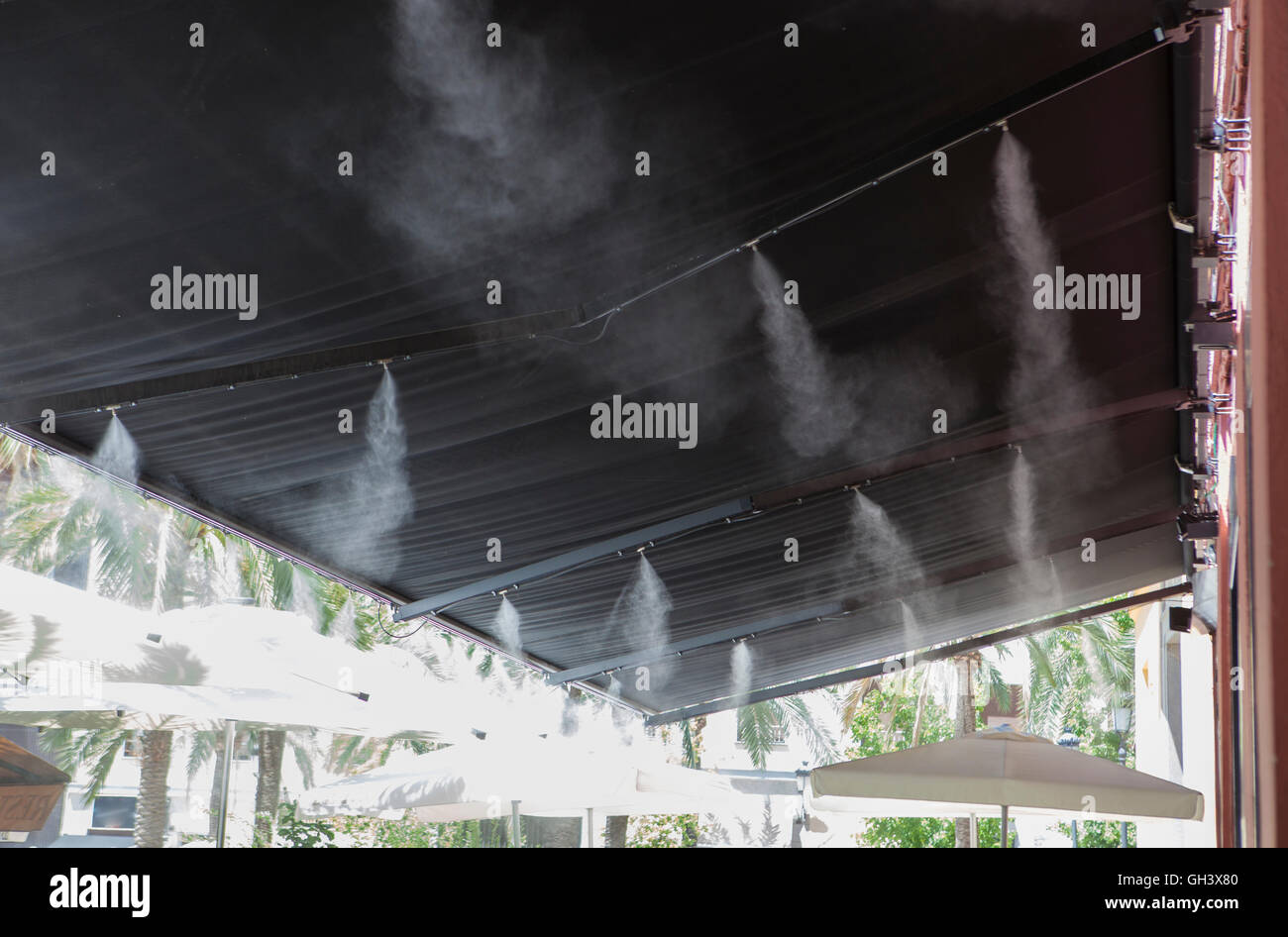 L'eau vaporisée éclaboussures sprinkleurs auvent terrasse au bar afin de refroidir la température de l'été en Espagne Banque D'Images