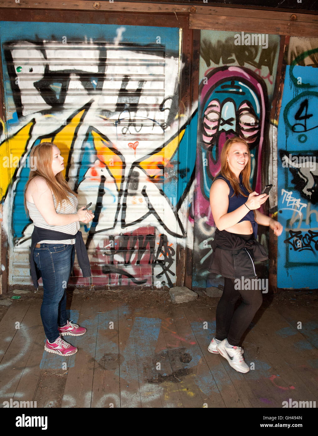 Les touristes quitter la boîte couverte de graffiti voitures dans l'accident de train parcours vtt forêt près de Whistler en Colombie-Britannique, Canada. Banque D'Images