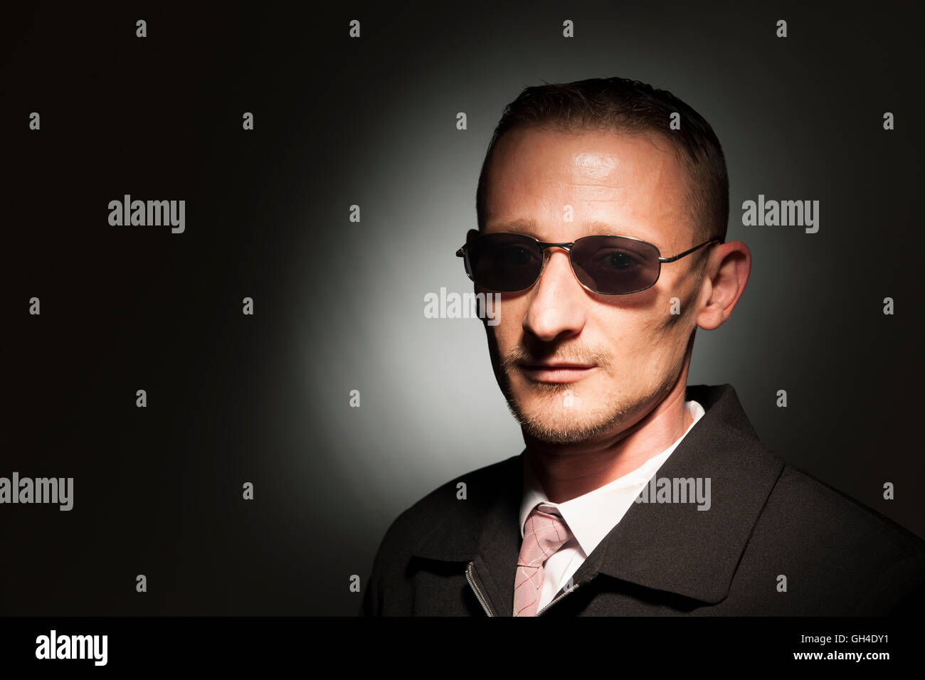 Tête et épaule portrait d'un homme d'âge moyen avec des lunettes dark background Studio avec spot light. Banque D'Images
