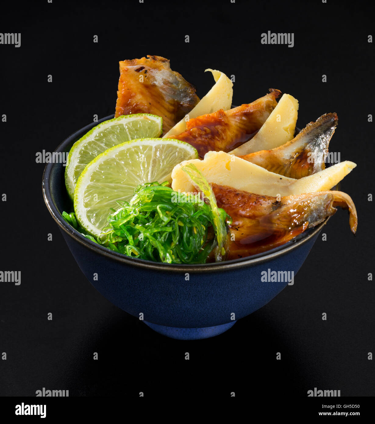 Poisson grillé avec salade d'algues, les citrons et le fromage dans un bol Banque D'Images