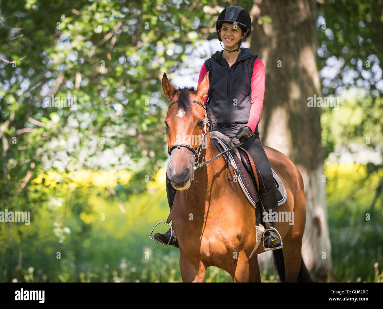 Jeune femme sur une promenade à cheval dans une forêt Banque D'Images