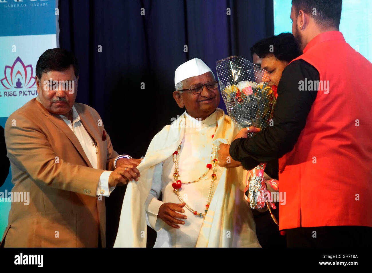 Anna Hazare être félicité par des fleurs et de l'affiche à châle cérémonie de dévoilement d'un prochain biopic. Banque D'Images