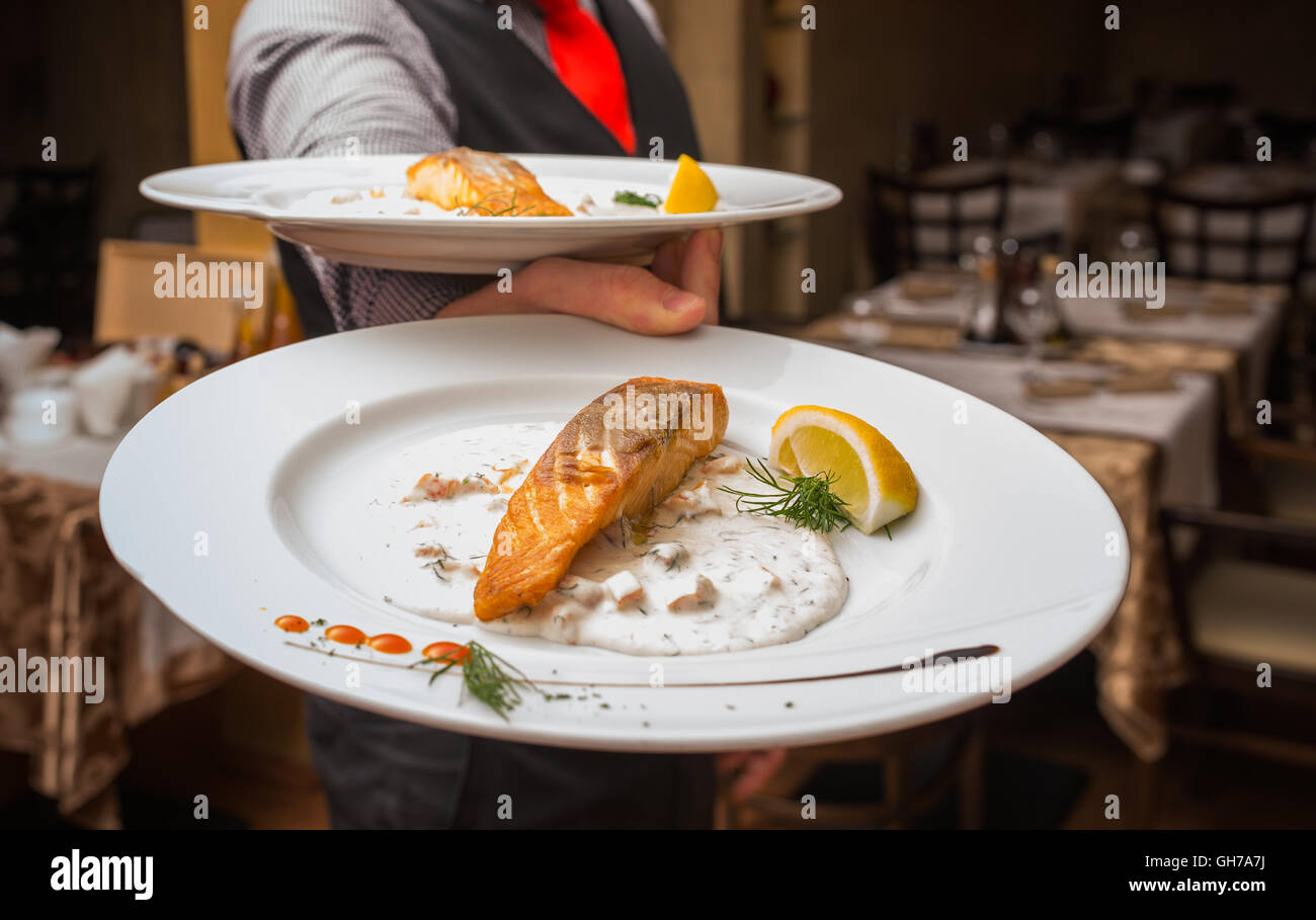 Waiter carrying une plaque avec plat de viande Banque D'Images