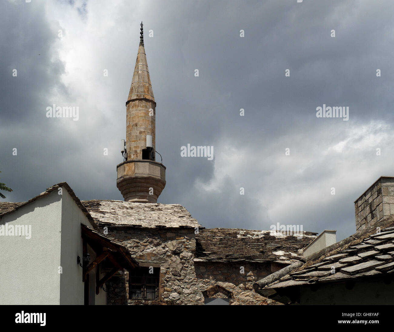 La tour de la mosquée avec des haut-parleurs pour l'appel à la prière et des tuiles de pierre et l'architecture vernaculaire typique de Mostar en Bosnie et Herzégovine Banque D'Images
