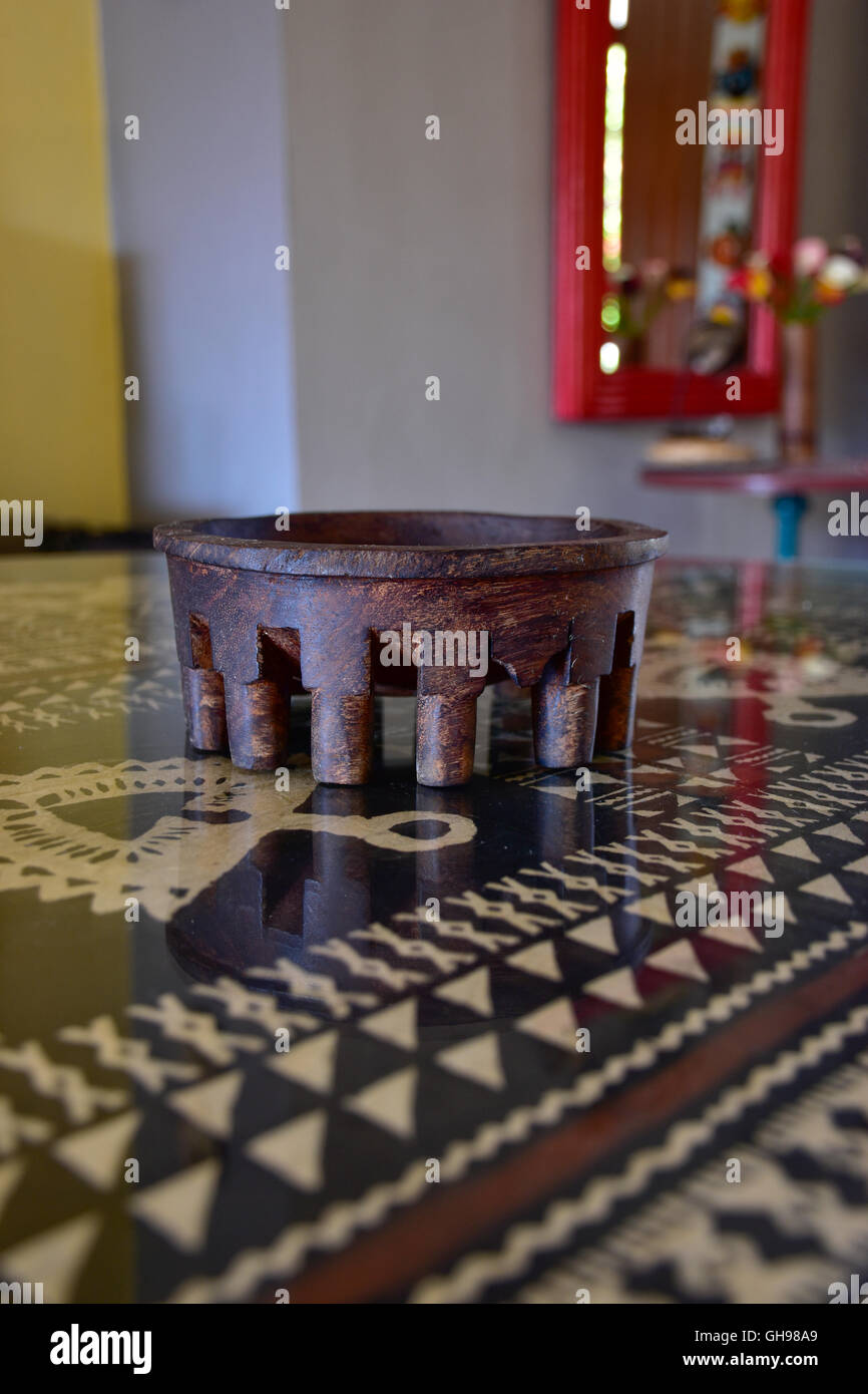 Tanoa Samoan antique ou laulau le kava bol sculpté dans du bois. Tapa Samoan chiffon sous verre sur table. Banque D'Images