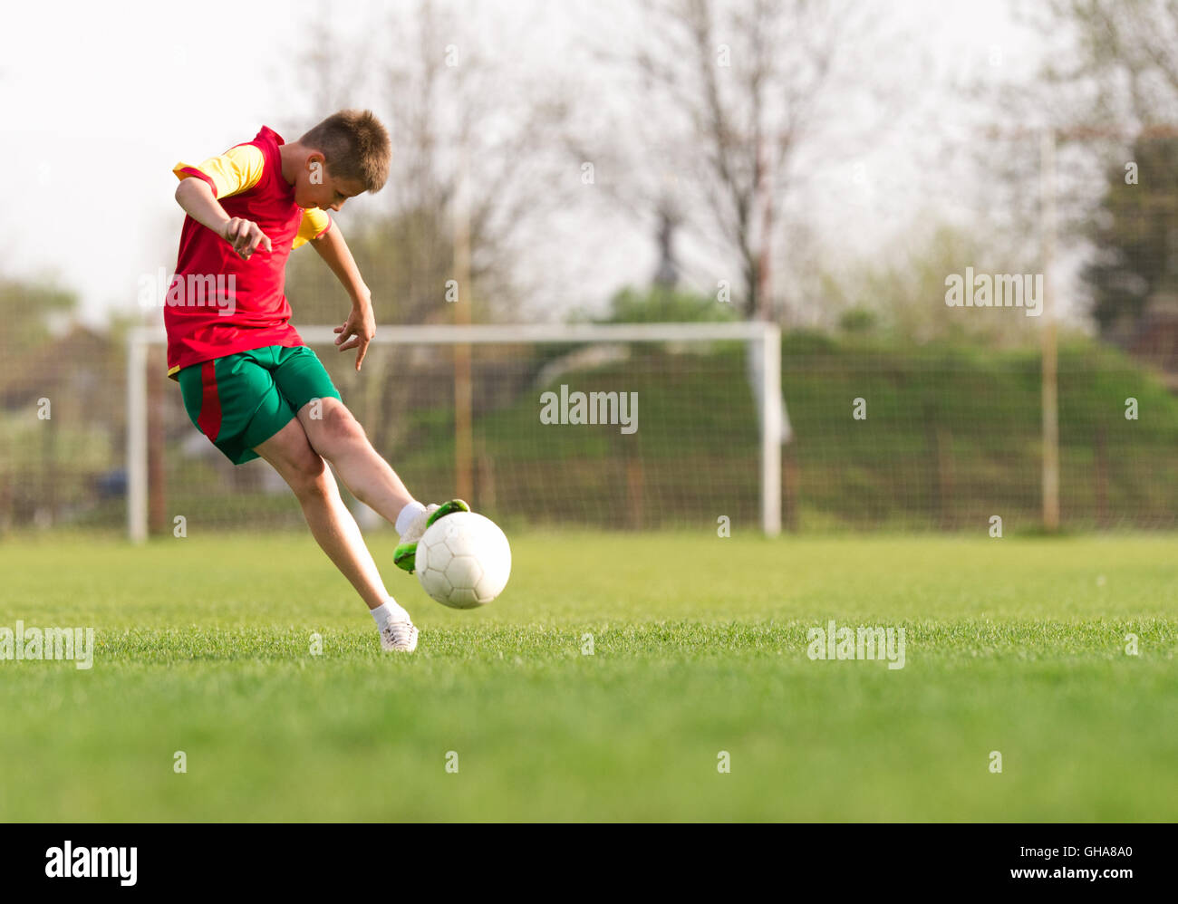 Les garçons des coups de football sur le terrain de sport Banque D'Images