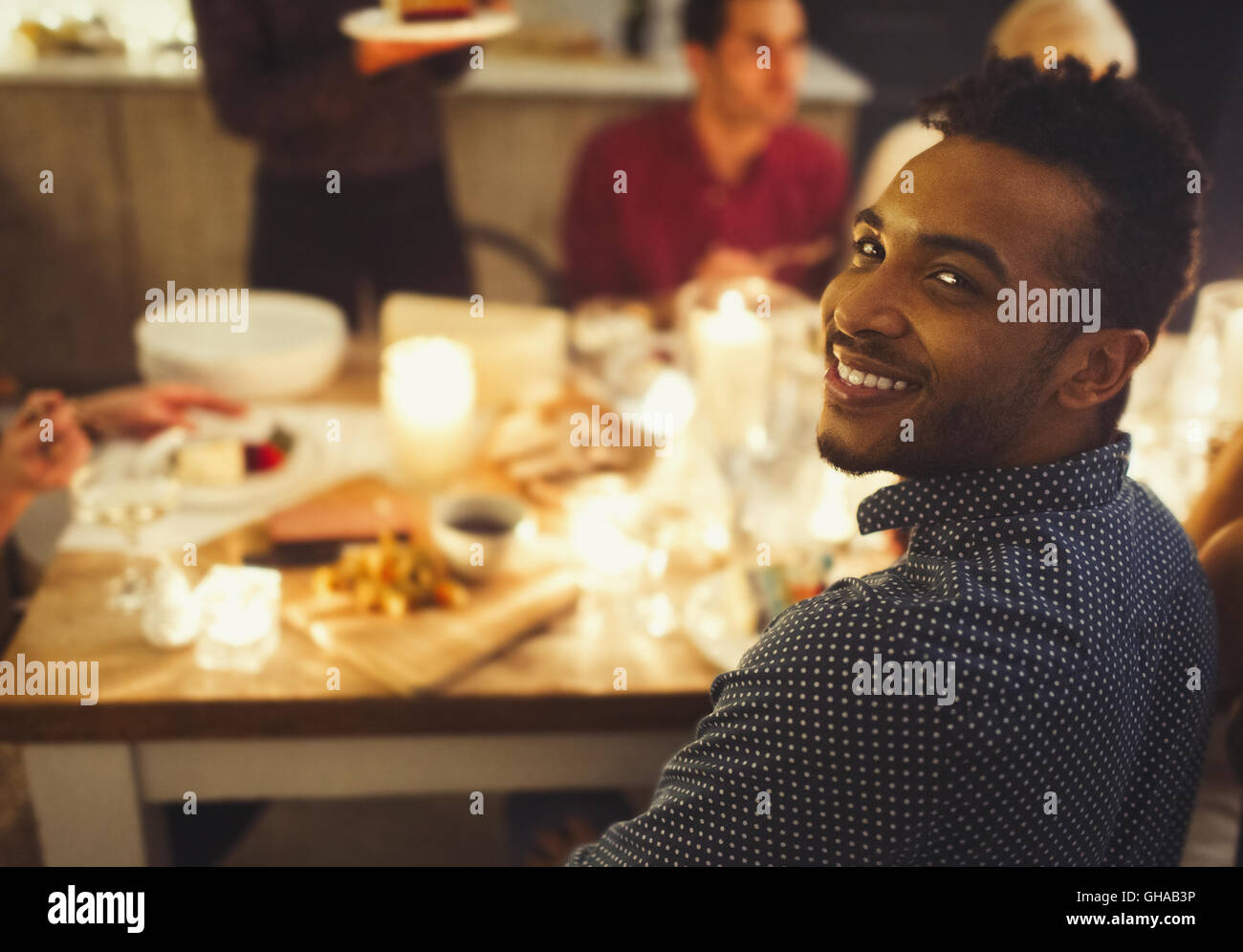 Portrait smiling man enjoying Christmas dinner aux chandelles Banque D'Images