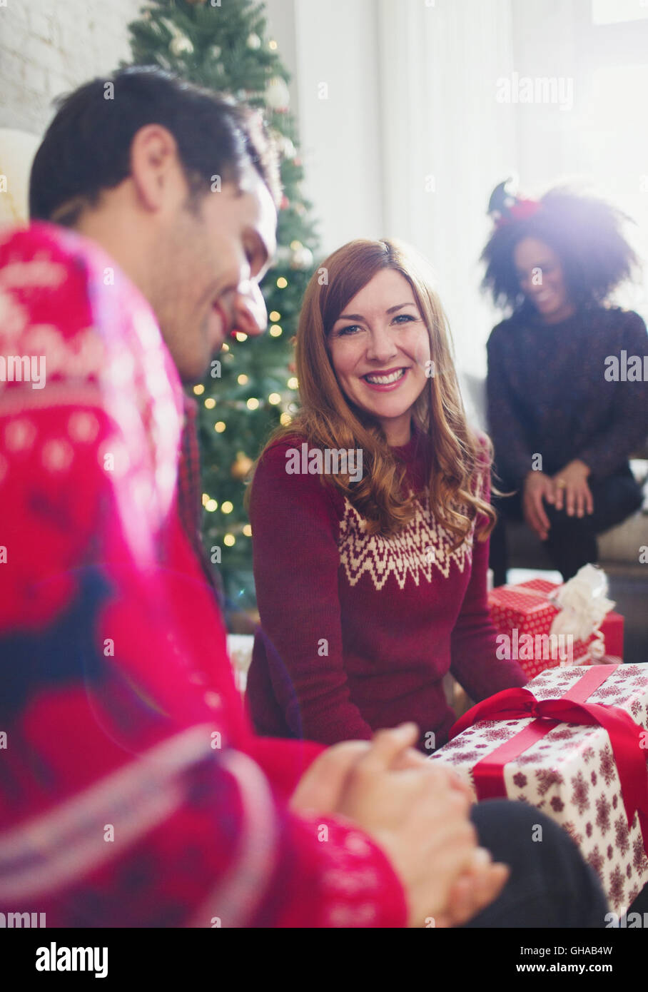 Portrait smiling woman ouverture des cadeaux de Noël avec des amis Banque D'Images