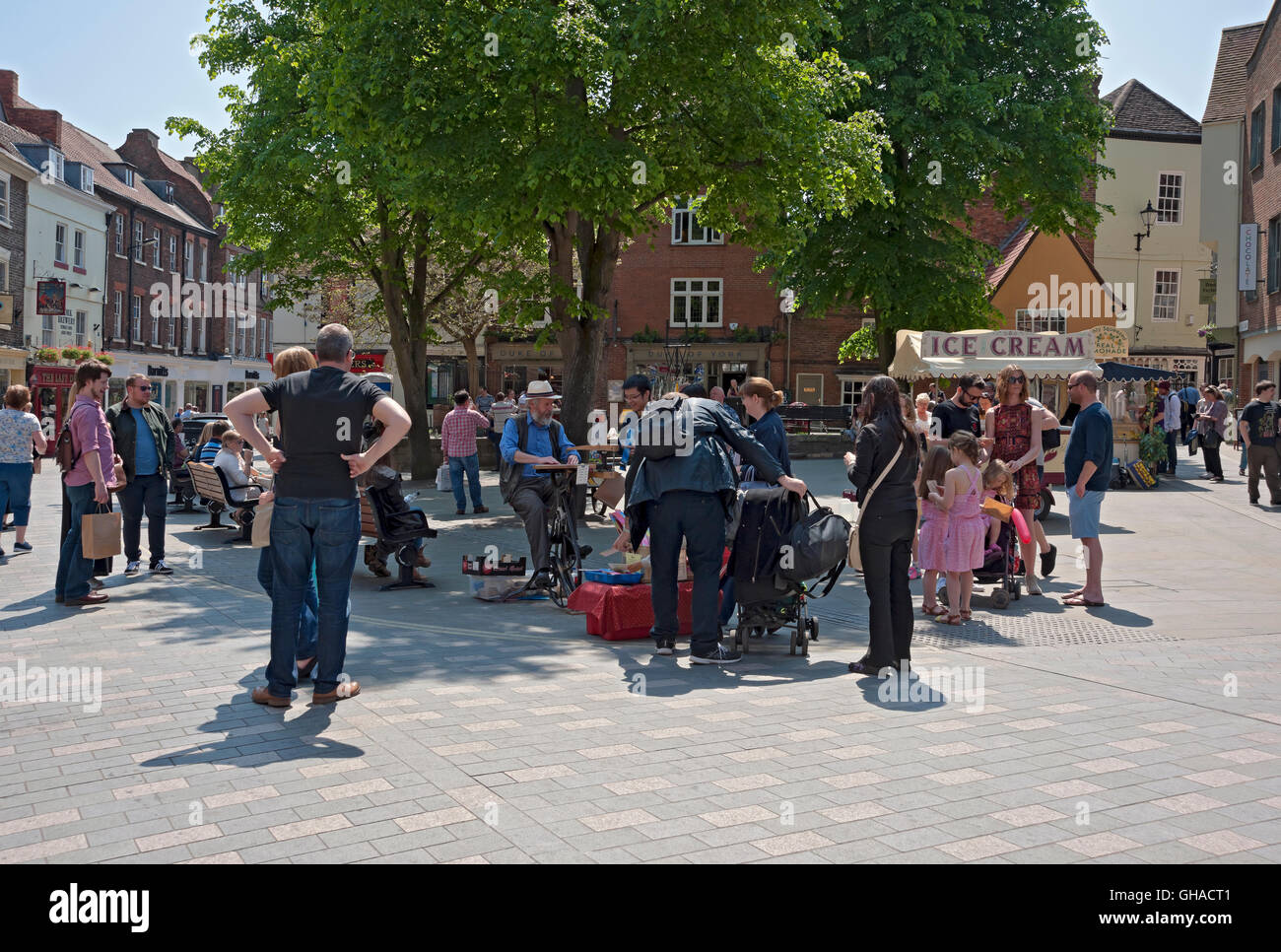 Visiteurs touristes les personnes profitant du soleil d'été dans le centre-ville Kings Square York North Yorkshire Angleterre Royaume-Uni GB Grande-Bretagne Banque D'Images