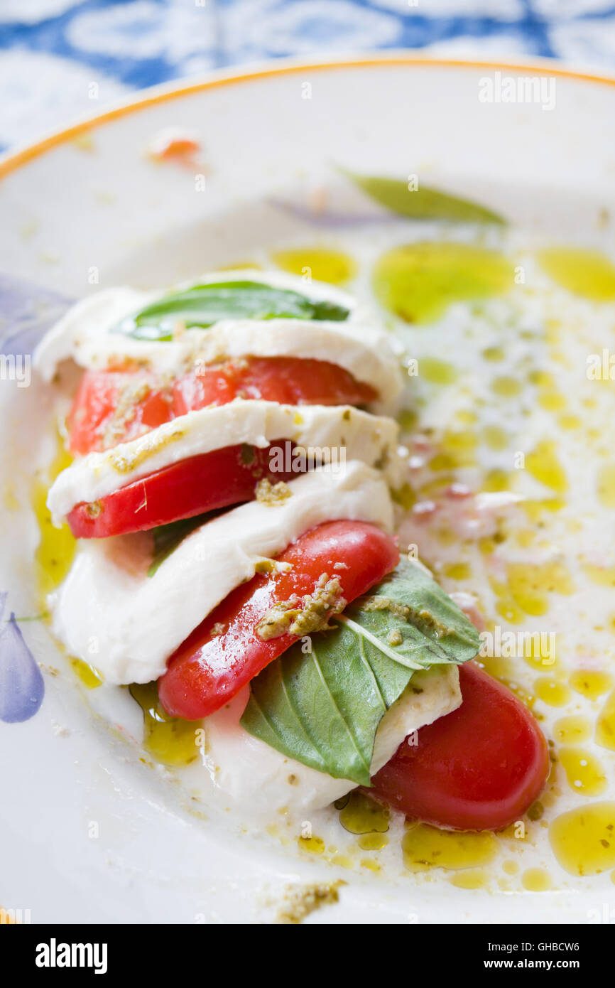 Salade Caprese faite de tranches de mozzarella, tomates et basilic vert, assaisonnées à l'huile d'olive Banque D'Images