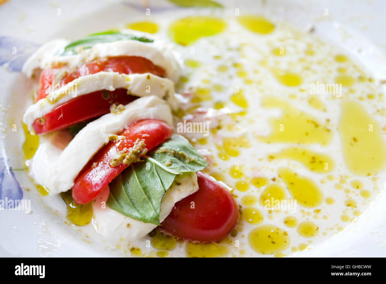 Salade Caprese faite de tranches de mozzarella, tomates et basilic vert, assaisonnées à l'huile d'olive Banque D'Images