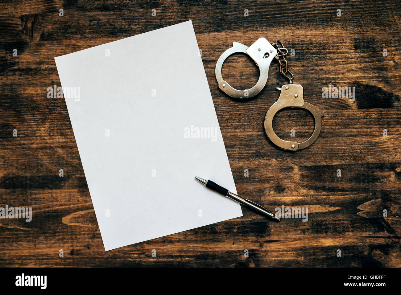 Menottes de police et le papier blanc sur le bureau du détective enquêteur, conception du droit et de la criminalité. Banque D'Images