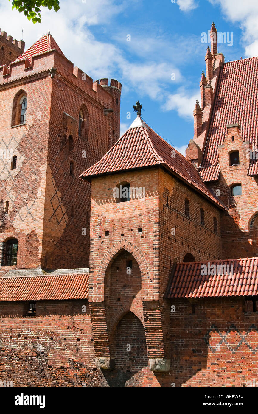 Une des tours du plus grand château de Malbork (brique) avec une statue de métal filinayu Pologne Banque D'Images