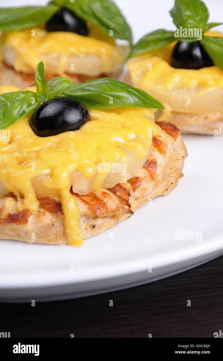 Morceaux de poitrine de poulet une tranche d'ananas avec du fromage , olives et basilic Banque D'Images