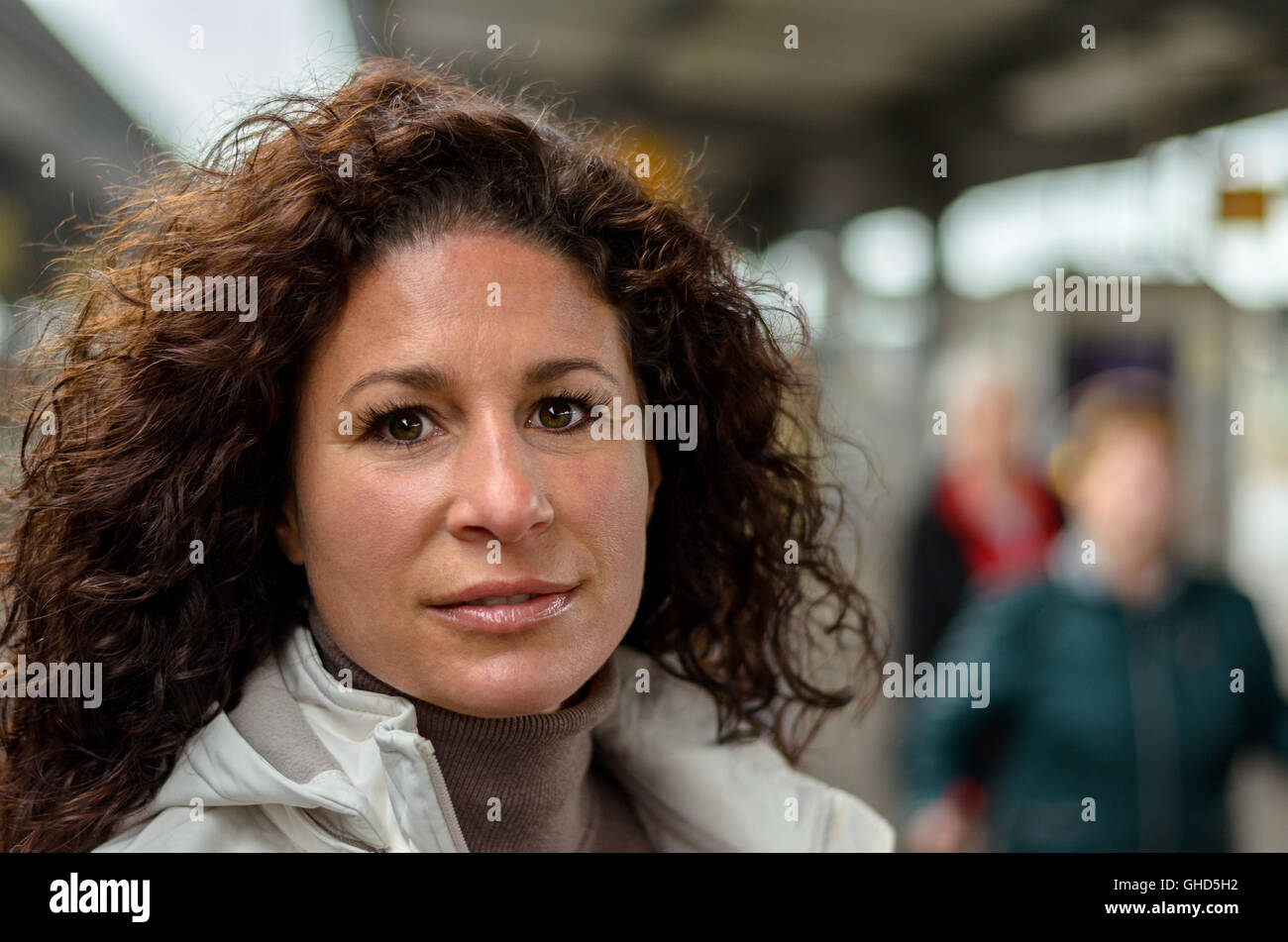 Jolie jeune femme voyageant dans un train en regardant la caméra avec un sourire tranquille, Close up head shot Banque D'Images