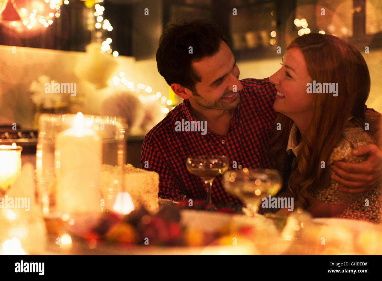 Affectionate couple hugging at candlelight dîner de Noël Banque D'Images
