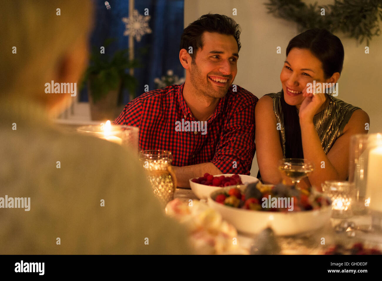 Smiling couple bénéficiant d'un repas de Noël aux chandelles Banque D'Images
