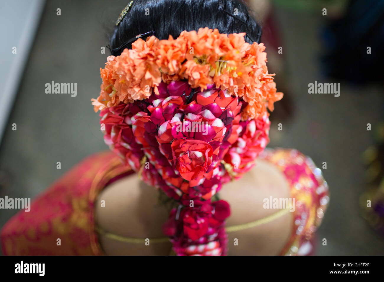 Des fleurs colorées dans les cheveux d'une Indienne mariée Banque D'Images