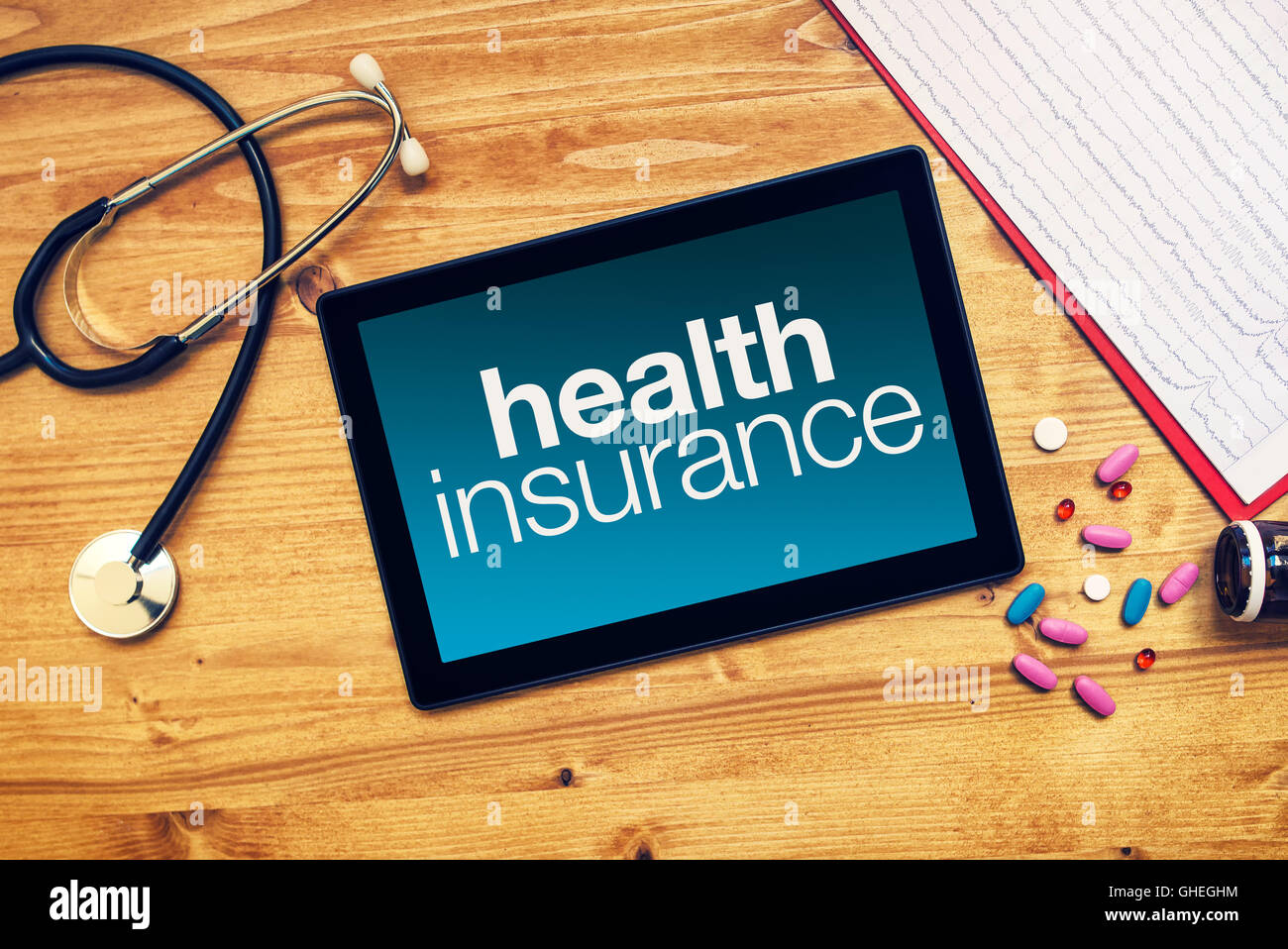 Assurance santé titre sur l'ordinateur tablette placée sur un bureau de travail, les médecins de l'image conceptuelle, vue du dessus Banque D'Images
