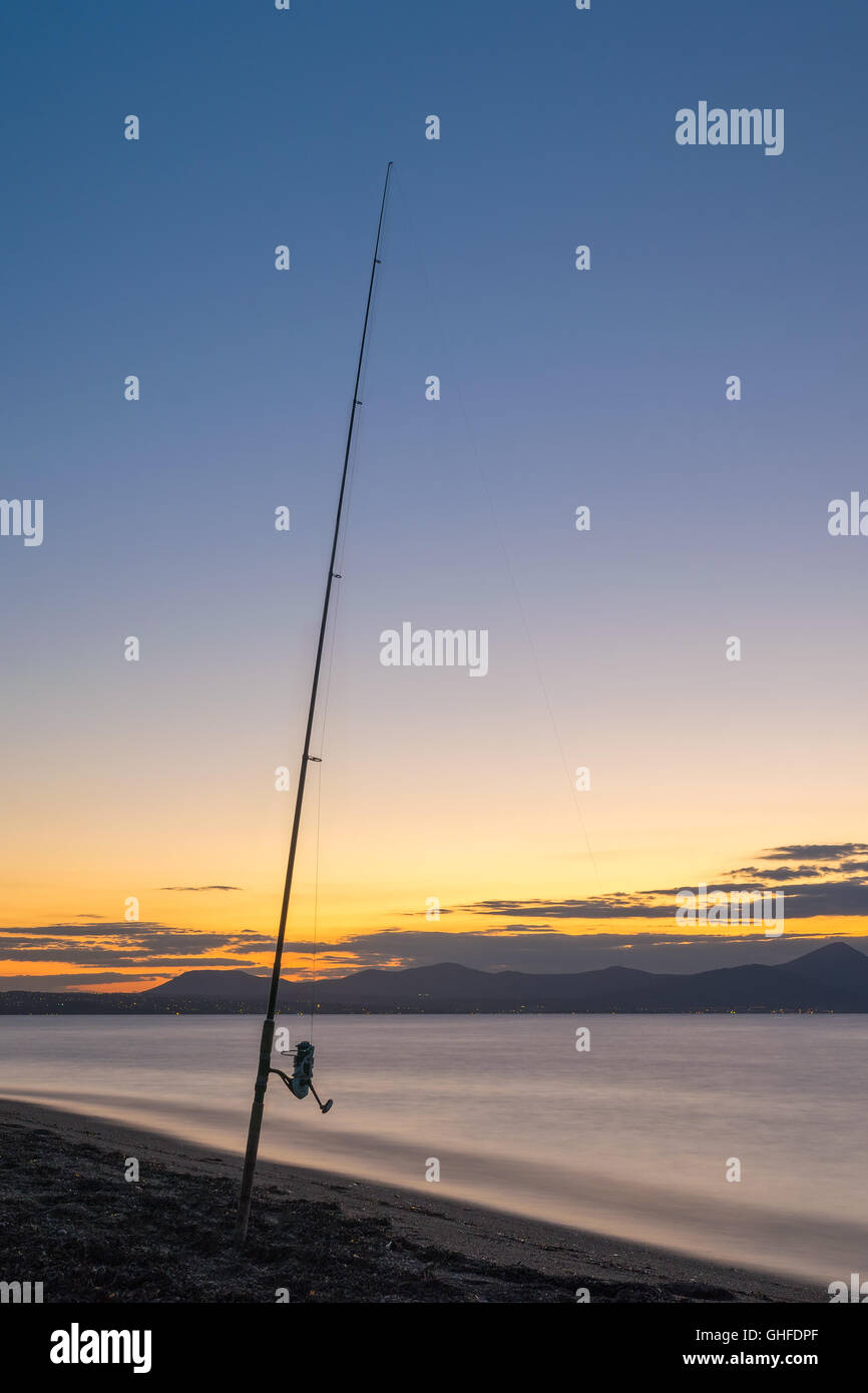 Canne à pêche contre le coucher du soleil. Banque D'Images