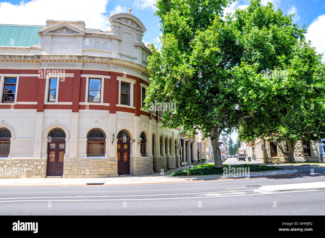 Ancien immeuble d'angle avec briques rouges et de calcaire, détail coin arrondi, arbre et Street View à Fremantle, Australie occidentale. Banque D'Images