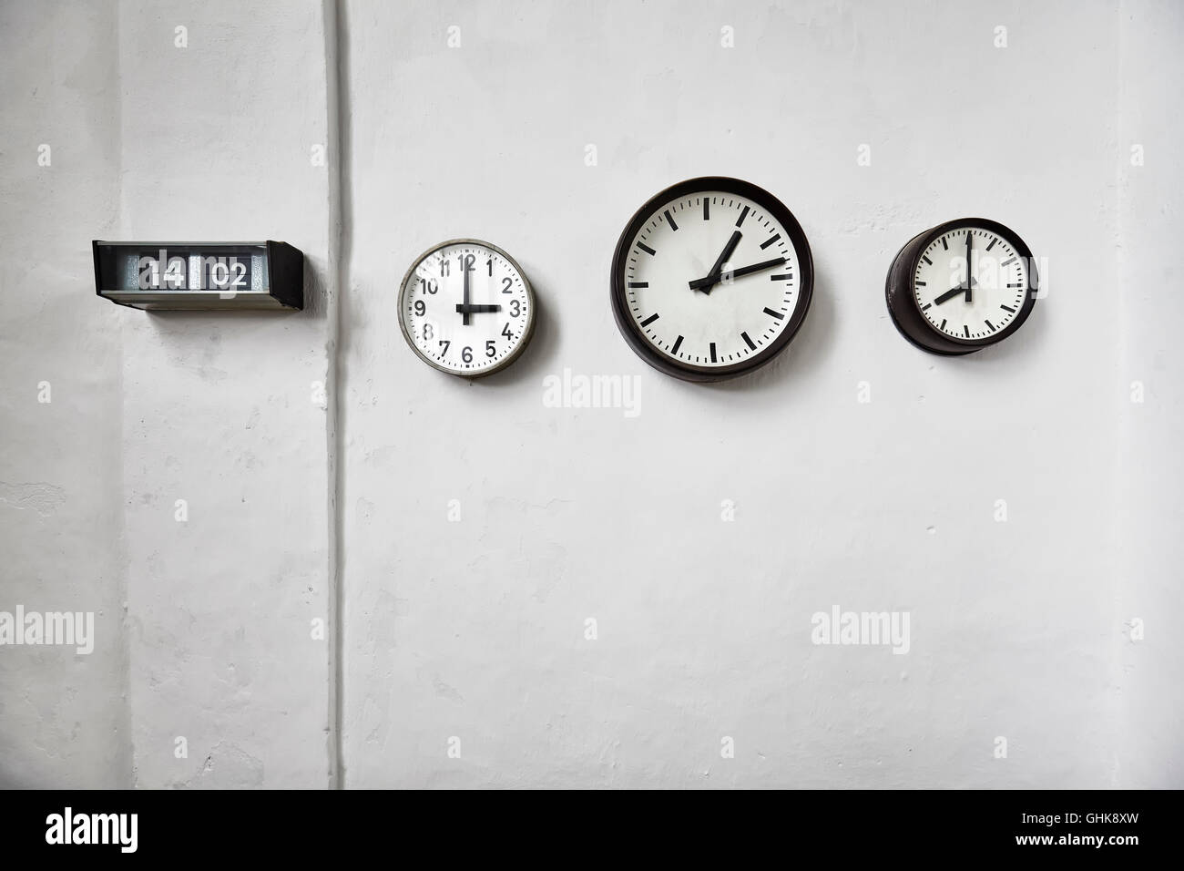 Horloges sur un mur blanc, temps qui passe, de l'espace concept pour le texte. Banque D'Images