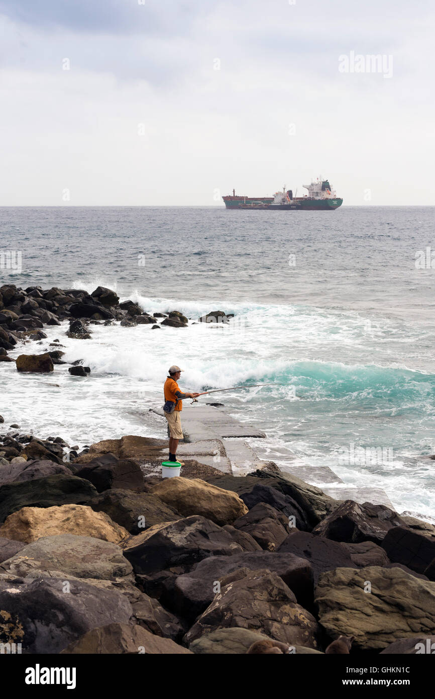 LAS PALMAS, GRAN CANARIA, ESPAGNE - le 29 juillet 2016 : pêcheur sur la côte de l'île de Gran Canaria, l'arrière-plan est un merch Banque D'Images