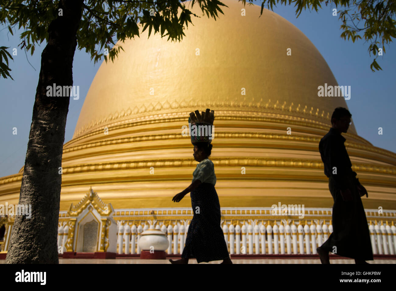 Femme marche et l'exercice sur l'élément head silhouette sur le dôme d'or de la Pagode Kaunghmudaw, Myanmar Banque D'Images